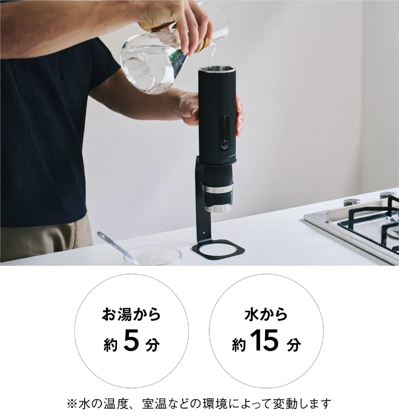 水差しから黒い円筒状の機械に水を注いでいる様子